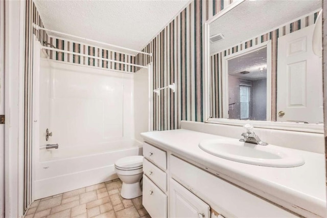 full bathroom featuring a textured ceiling, toilet, vanity, washtub / shower combination, and wallpapered walls