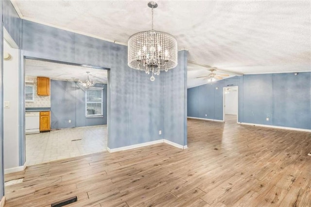 unfurnished dining area featuring lofted ceiling, light wood-style floors, visible vents, and ceiling fan with notable chandelier