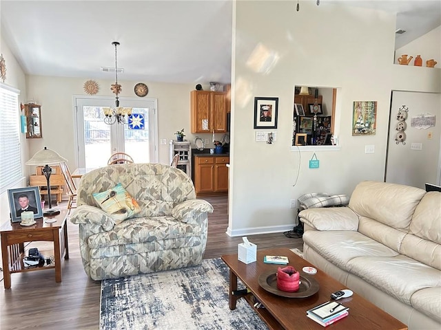 living room with dark hardwood / wood-style flooring and an inviting chandelier