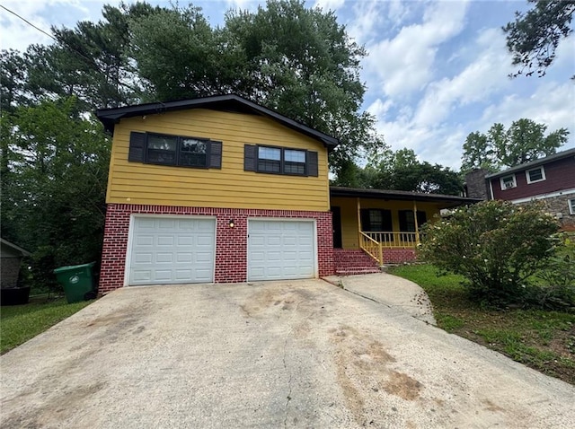 4246 Rue Saint Michel, Stone Mountain, GA 30083 - tri-level home featuring covered porch, brick siding, an attached garage, and concrete driveway