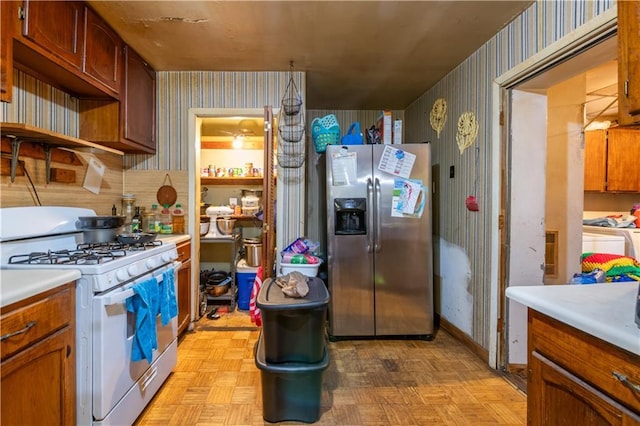 379 Utoy Cir SW, Atlanta, GA 30331 - kitchen with stainless steel fridge with ice dispenser, white range with gas cooktop, wallpapered walls, and light countertops