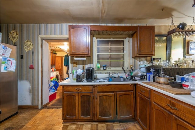 379 Utoy Cir SW, Atlanta, GA 30331 - kitchen featuring light countertops, wallpapered walls, separate washer and dryer, and brown cabinetry