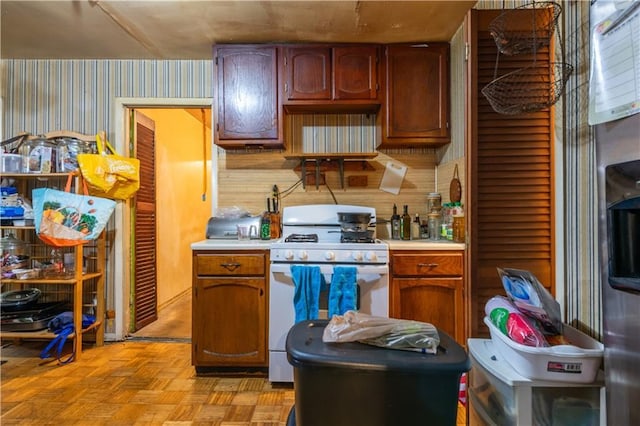 379 Utoy Cir SW, Atlanta, GA 30331 - kitchen featuring white range with gas cooktop, wallpapered walls, and light countertops