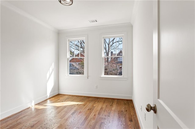 spare room featuring ornamental molding and light hardwood / wood-style flooring