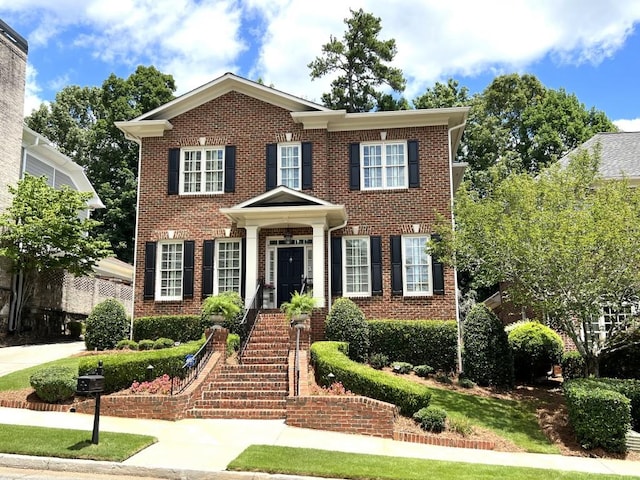 view of front of home with driveway and brick siding