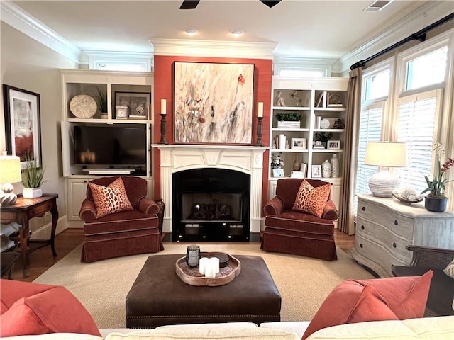 living area with ornamental molding, visible vents, and a fireplace with flush hearth