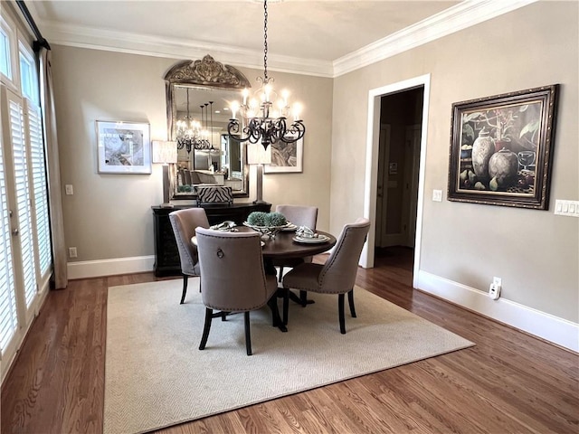 dining room featuring a chandelier, crown molding, wood finished floors, and baseboards