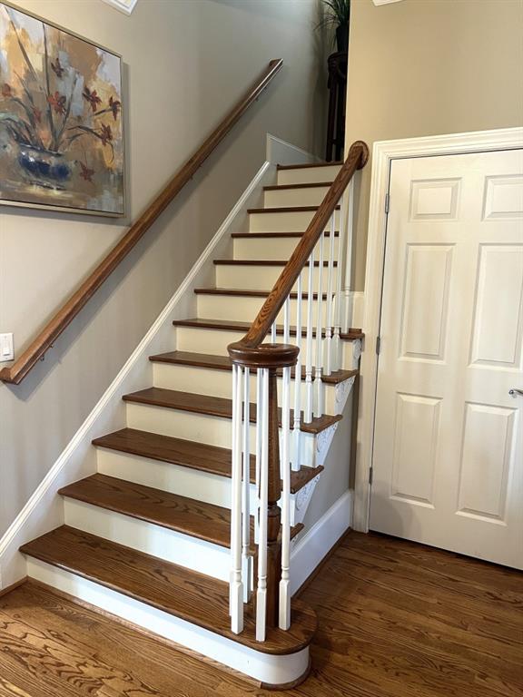 staircase featuring baseboards and wood finished floors