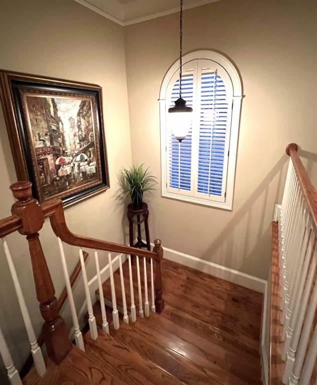 staircase with baseboards, wood finished floors, and crown molding