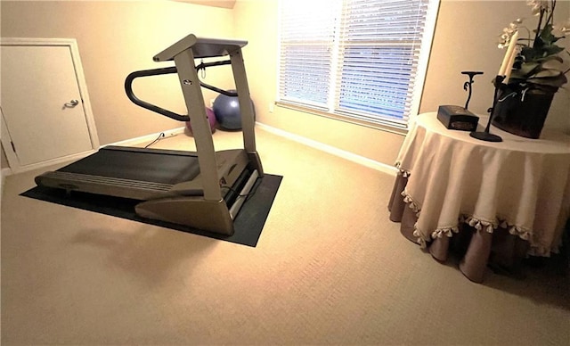 exercise room with baseboards and carpet