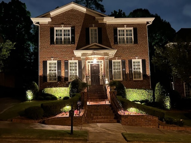 view of front of home with stairway and brick siding