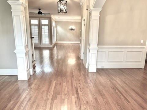 interior space with ornate columns, ceiling fan, and wood finished floors