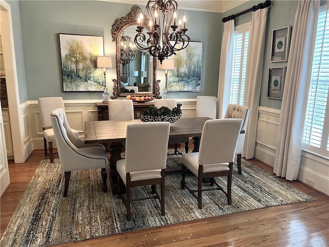 dining area with a wainscoted wall, light wood finished floors, and a decorative wall