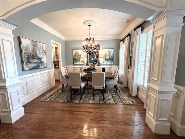 dining area with dark wood-type flooring, plenty of natural light, and arched walkways