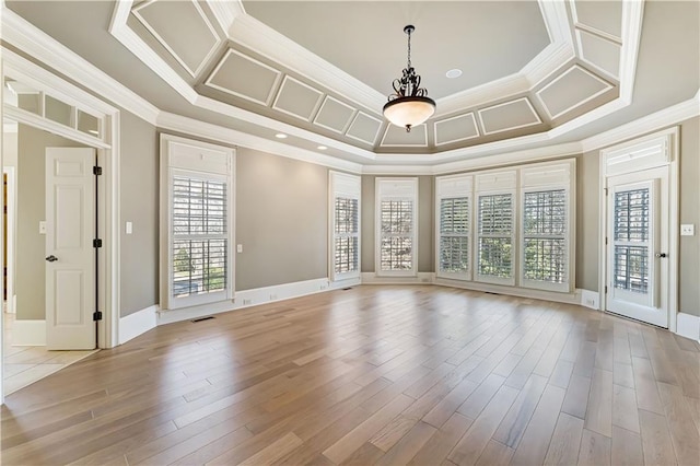 empty room with crown molding, coffered ceiling, baseboards, and light wood finished floors