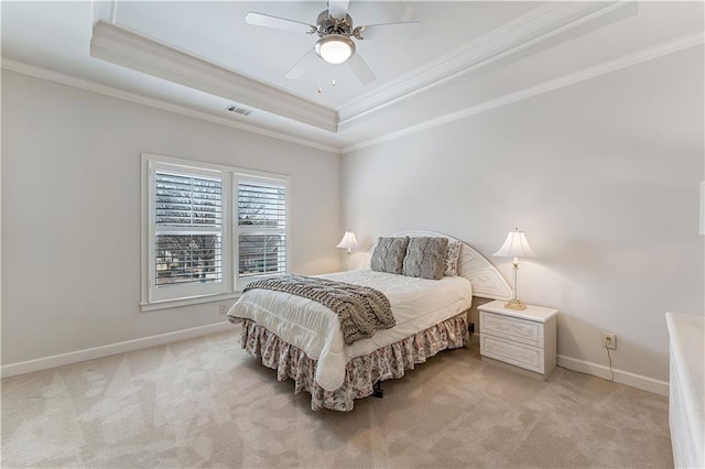 bedroom featuring a tray ceiling, baseboards, light colored carpet, and crown molding