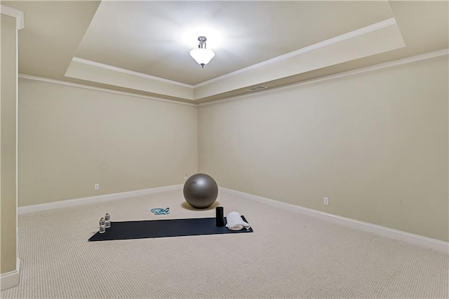 exercise room with visible vents, carpet floors, baseboards, crown molding, and a raised ceiling