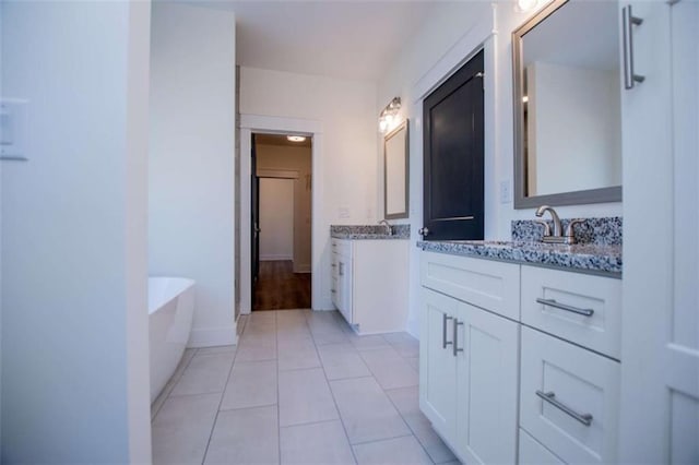 bathroom with tile patterned floors, vanity, and a bath