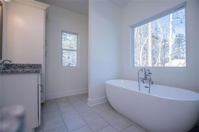 bathroom with tile patterned flooring, vanity, and a tub