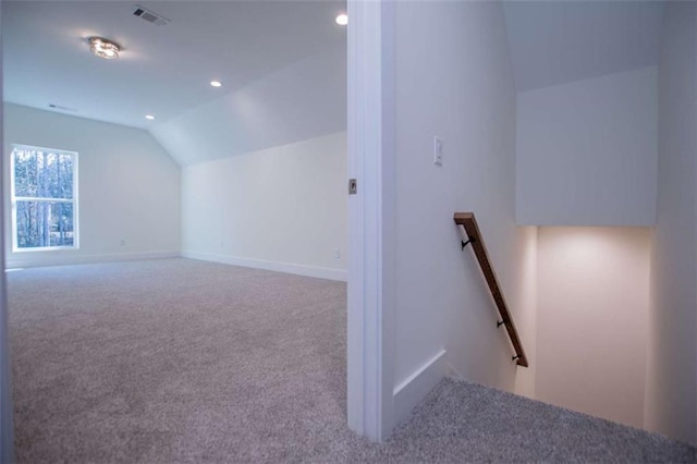 additional living space featuring lofted ceiling and carpet