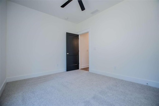 carpeted spare room featuring ceiling fan