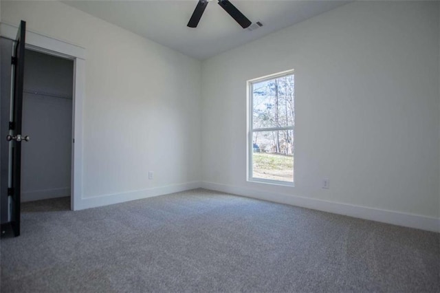 carpeted spare room featuring ceiling fan