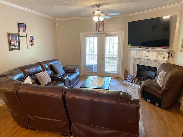 living room with hardwood / wood-style flooring, ceiling fan, a textured ceiling, and french doors