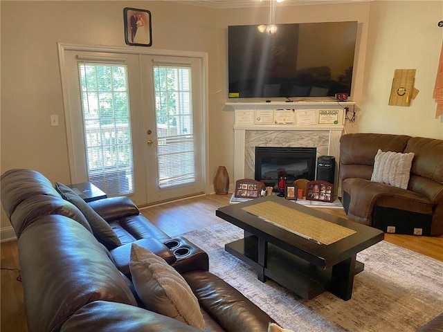 living room featuring light wood-type flooring, french doors, and a high end fireplace