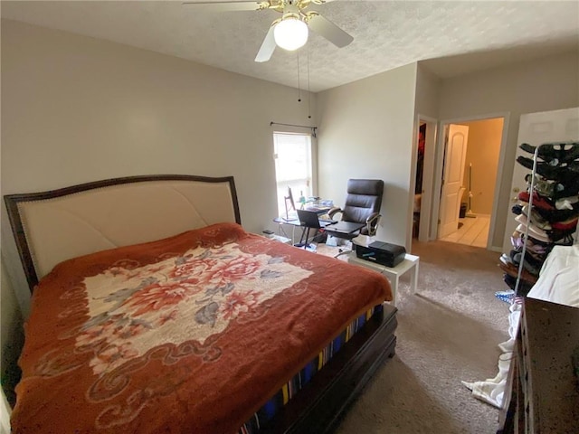 bedroom with ceiling fan, carpet, ensuite bathroom, and a textured ceiling