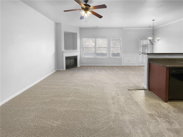 unfurnished living room with baseboards, light colored carpet, ornamental molding, a fireplace, and ceiling fan with notable chandelier