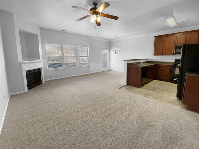 kitchen featuring light colored carpet, a peninsula, a fireplace, open floor plan, and black appliances