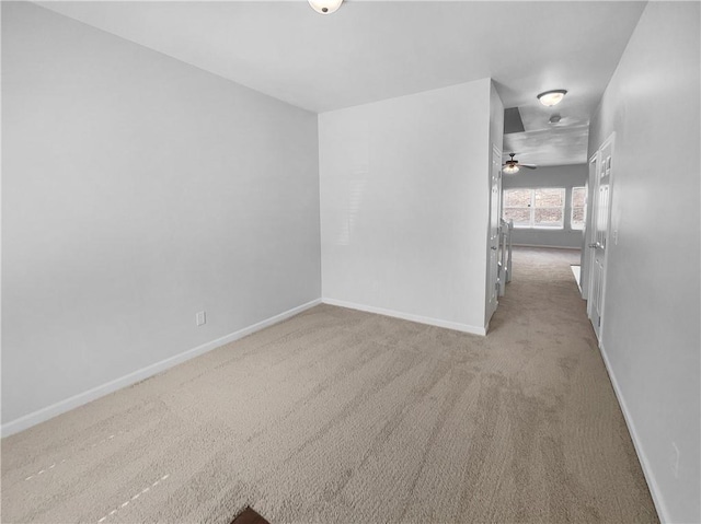 empty room featuring light carpet and baseboards