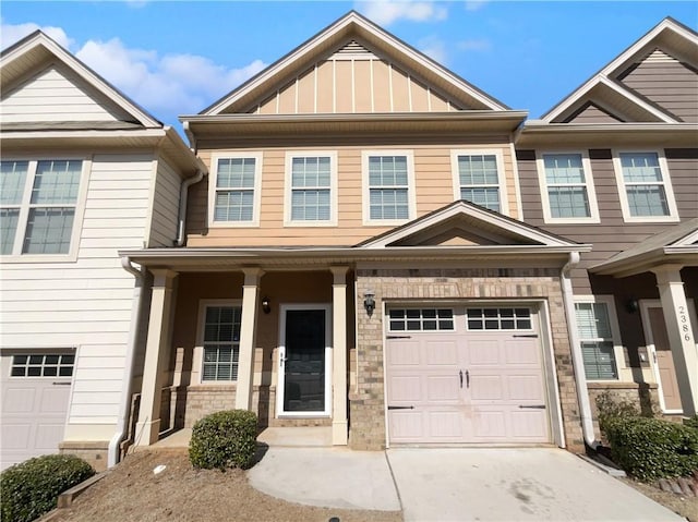 townhome / multi-family property featuring a garage, driveway, a porch, and board and batten siding