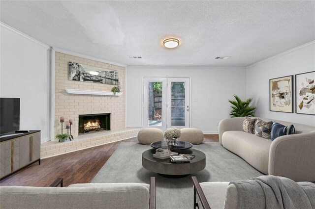 706 Twin Brooks Ct SE, Marietta, GA 30067 - living room with a brick fireplace, visible vents, ornamental molding, and wood finished floors