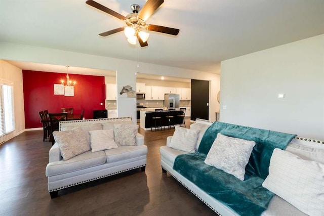 living room featuring a chandelier, dark wood-type flooring, and a ceiling fan