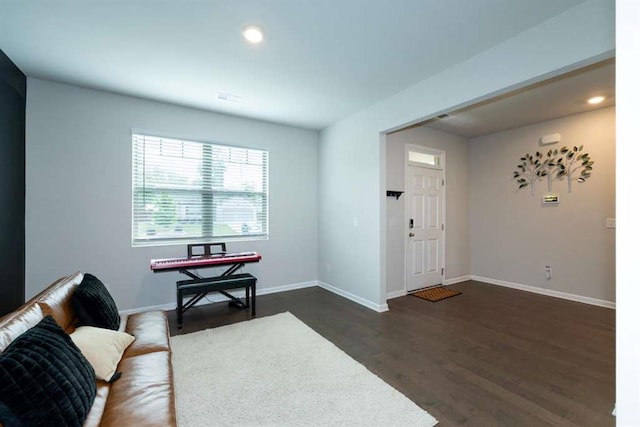 living room featuring dark wood-style flooring, baseboards, and recessed lighting