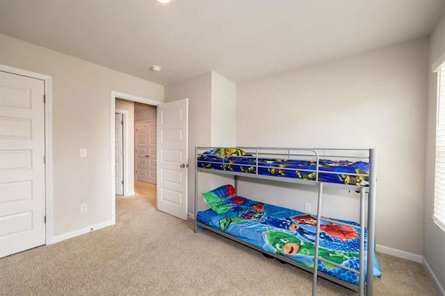 bedroom featuring carpet, baseboards, and multiple windows