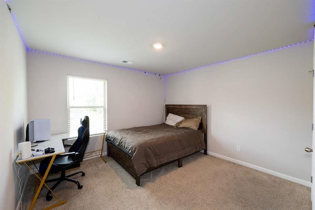 bedroom featuring light carpet, baseboards, and a desk