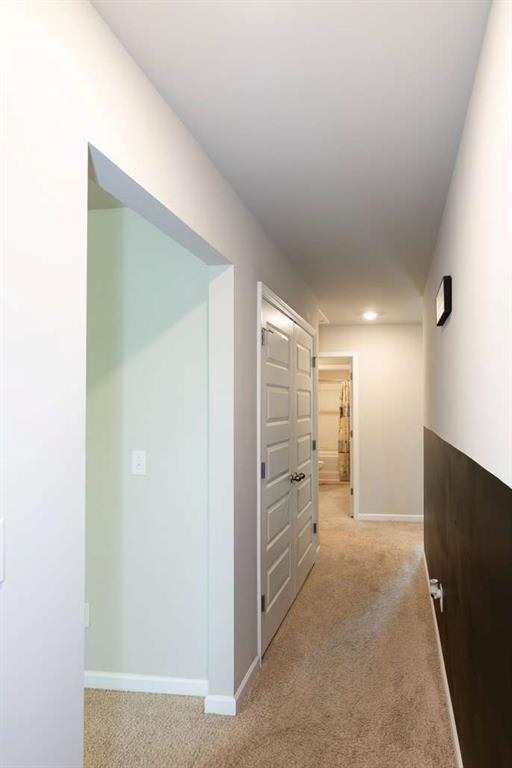 hallway with light carpet, baseboards, and recessed lighting