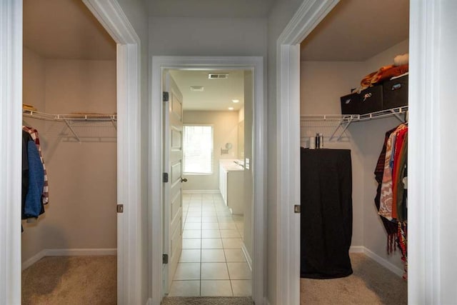 spacious closet featuring carpet and tile patterned flooring