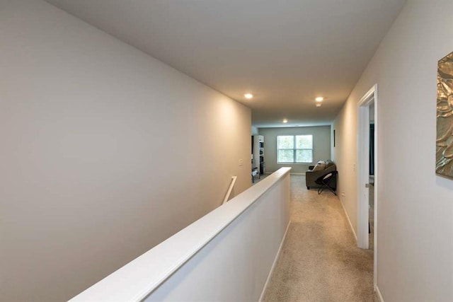 hallway featuring recessed lighting, light carpet, an upstairs landing, and baseboards