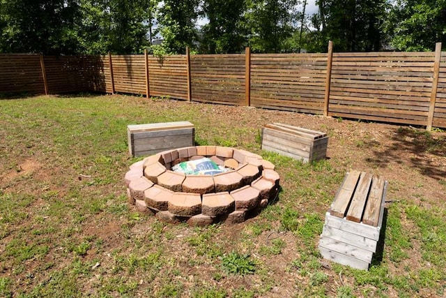 view of yard with a fire pit and view of scattered trees