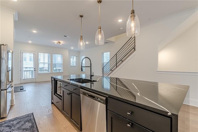 kitchen featuring hanging light fixtures, light hardwood / wood-style floors, white cabinetry, and appliances with stainless steel finishes