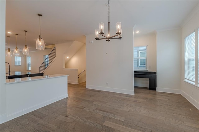 kitchen featuring hardwood / wood-style floors, kitchen peninsula, hanging light fixtures, a breakfast bar, and white cabinetry