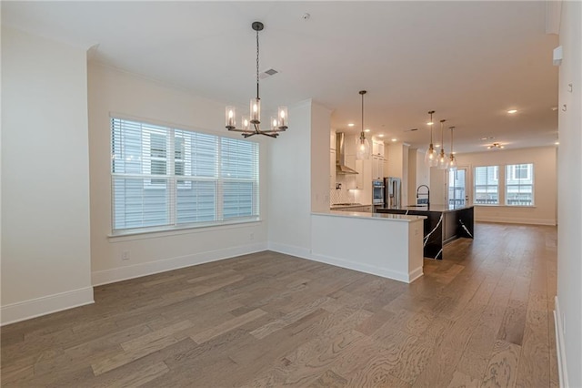 unfurnished living room with wood-type flooring and ornamental molding