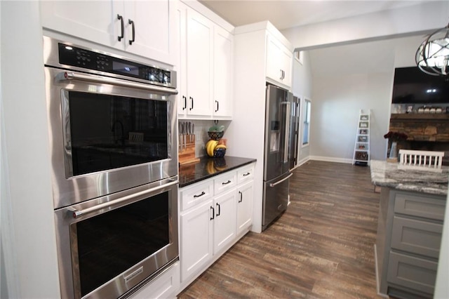 223 Deans Dr, Dawsonville, GA 30534 - kitchen with high end refrigerator, double oven, dark stone counters, dark wood-style floors, and white cabinets