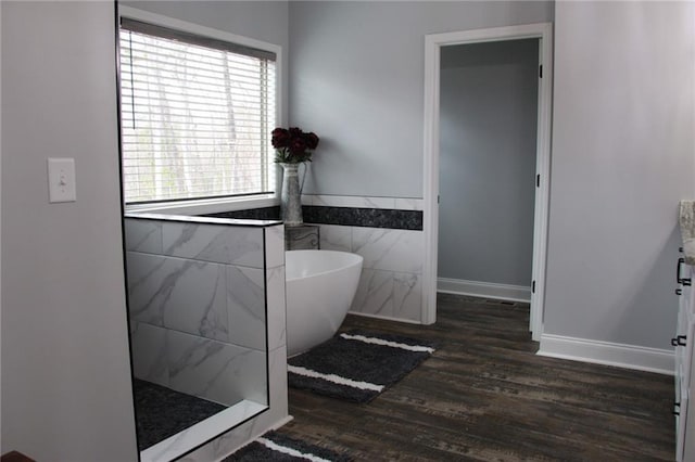 223 Deans Dr, Dawsonville, GA 30534 - bathroom featuring wood finished floors, a freestanding tub, tile walls, walk in shower, and wainscoting
