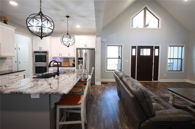 223 Deans Dr, Dawsonville, GA 30534 - kitchen featuring a chandelier, appliances with stainless steel finishes, dark wood-type flooring, a sink, and light stone counters
