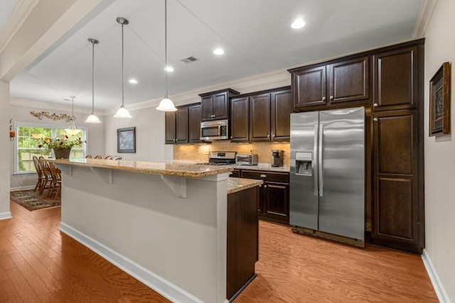 325 Rdg Hill Cir Unit 3, Marietta, GA 30064 - kitchen with stainless steel appliances, baseboards, a breakfast bar area, an island with sink, and light wood-style flooring