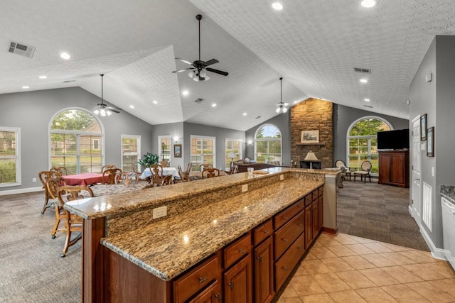 325 Rdg Hill Cir Unit 3, Marietta, GA 30064 - kitchen featuring light carpet, a ceiling fan, open floor plan, lofted ceiling, and a stone fireplace